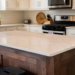 Stained-wood island with quartz countertop in a $30,000 Plano kitchen remodel by UHS Remodeling