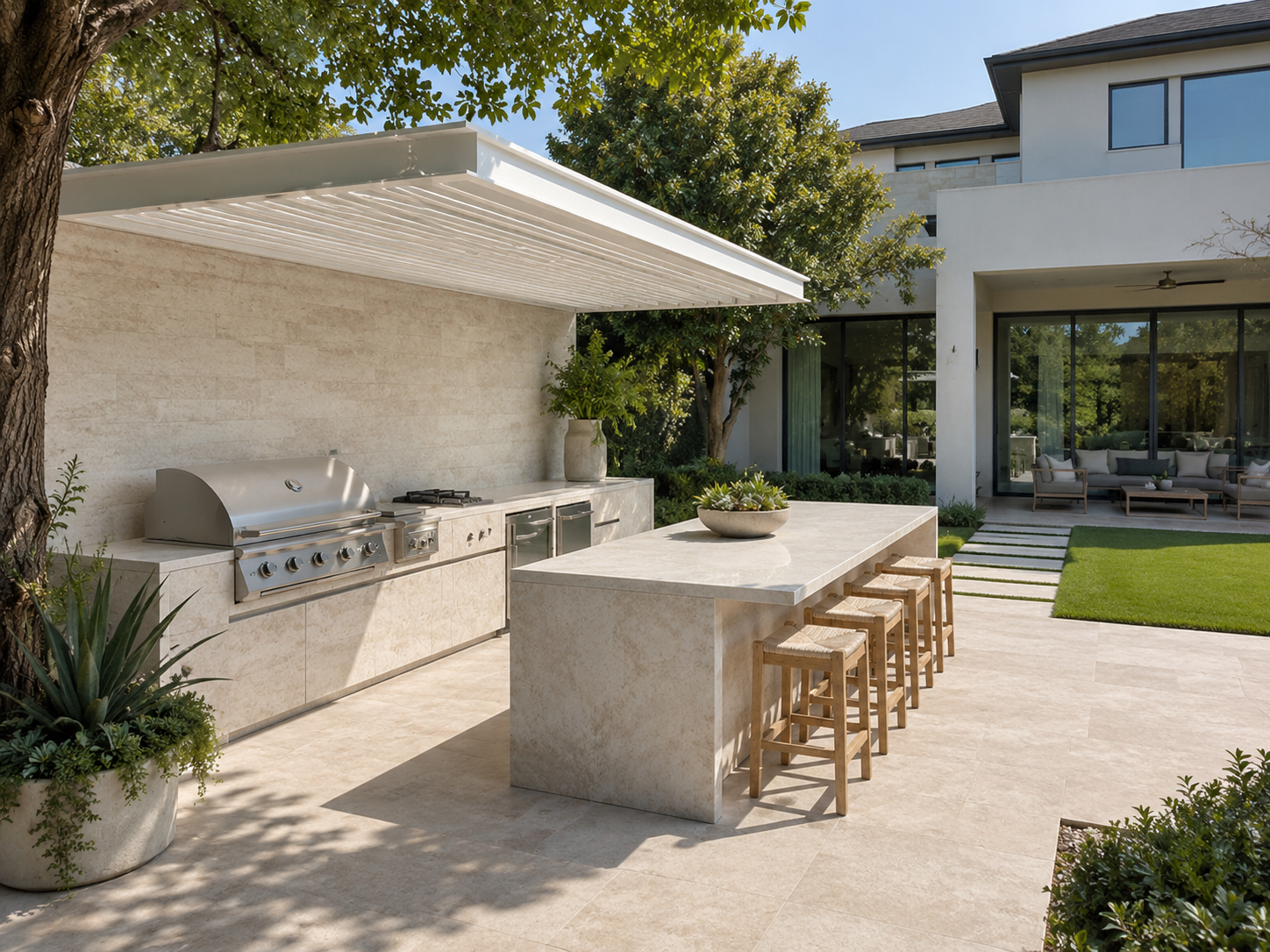 Modern travertine outdoor kitchen with a built-in grill, a large island with bar seating, and a retractable louvered roof