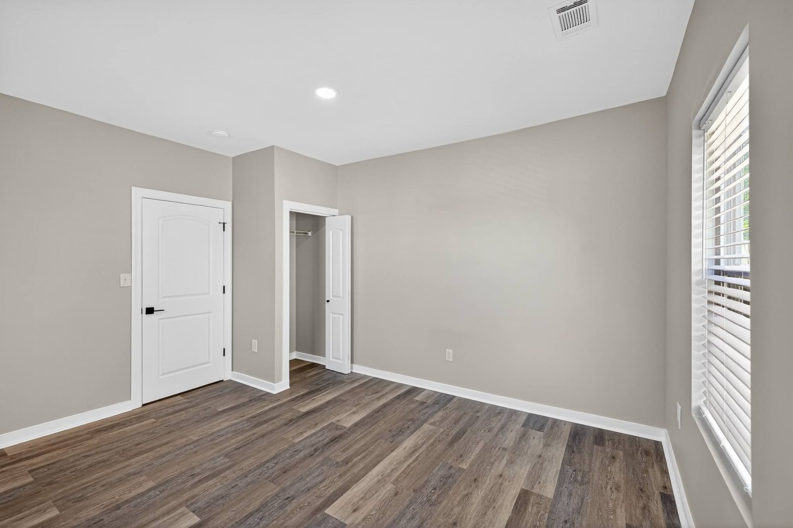 Finished bedroom with wood floors in a Frisco, TX interior remodel by UHS Remodeling
