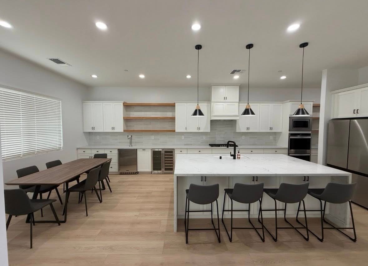 Open white kitchen with a marble island and pendant lighting in a Richardson, TX interior remodel by UHS Remodeling