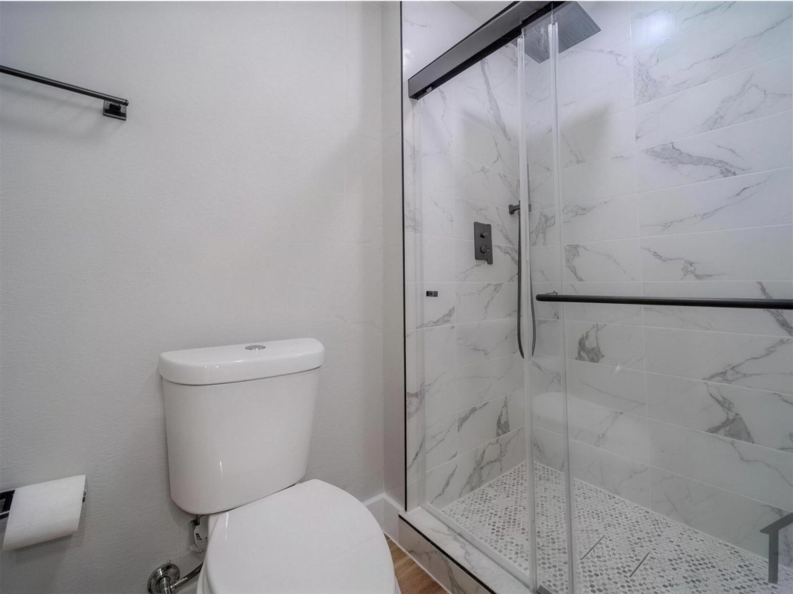 Bathroom remodel in Garland, TX — marble shower pebble floor — UHS Remodeling project