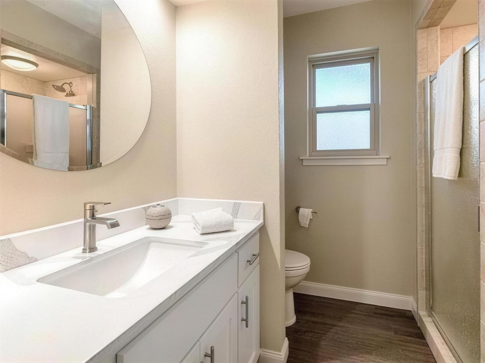 Bathroom remodel in Carrollton, TX — round mirror single vanity — UHS Remodeling project