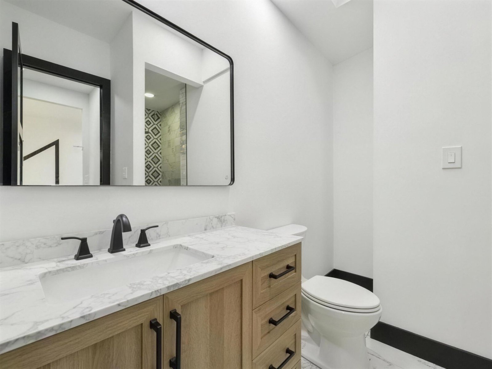 Bathroom remodel in Plano, TX — white oak vanity black mirror — UHS Remodeling project