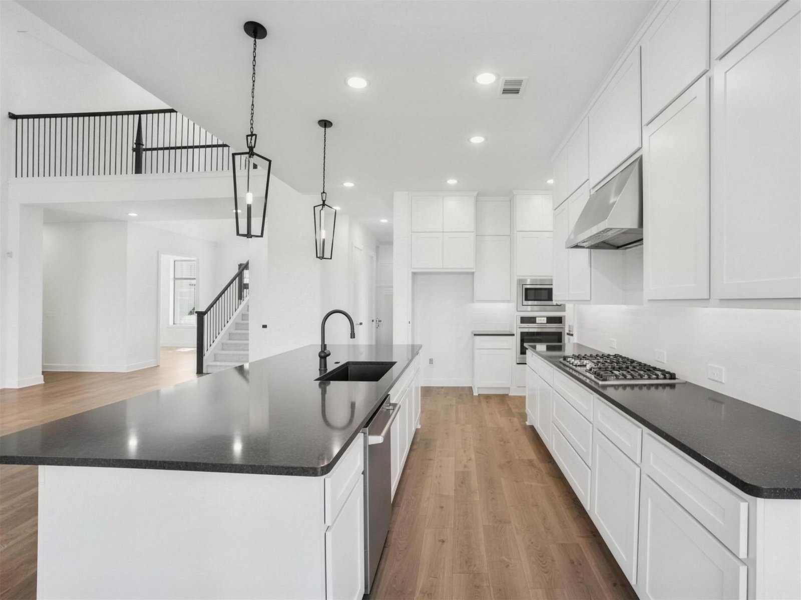 Kitchen remodel in Rockwall, TX — dark quartz island lanterns — UHS Remodeling project