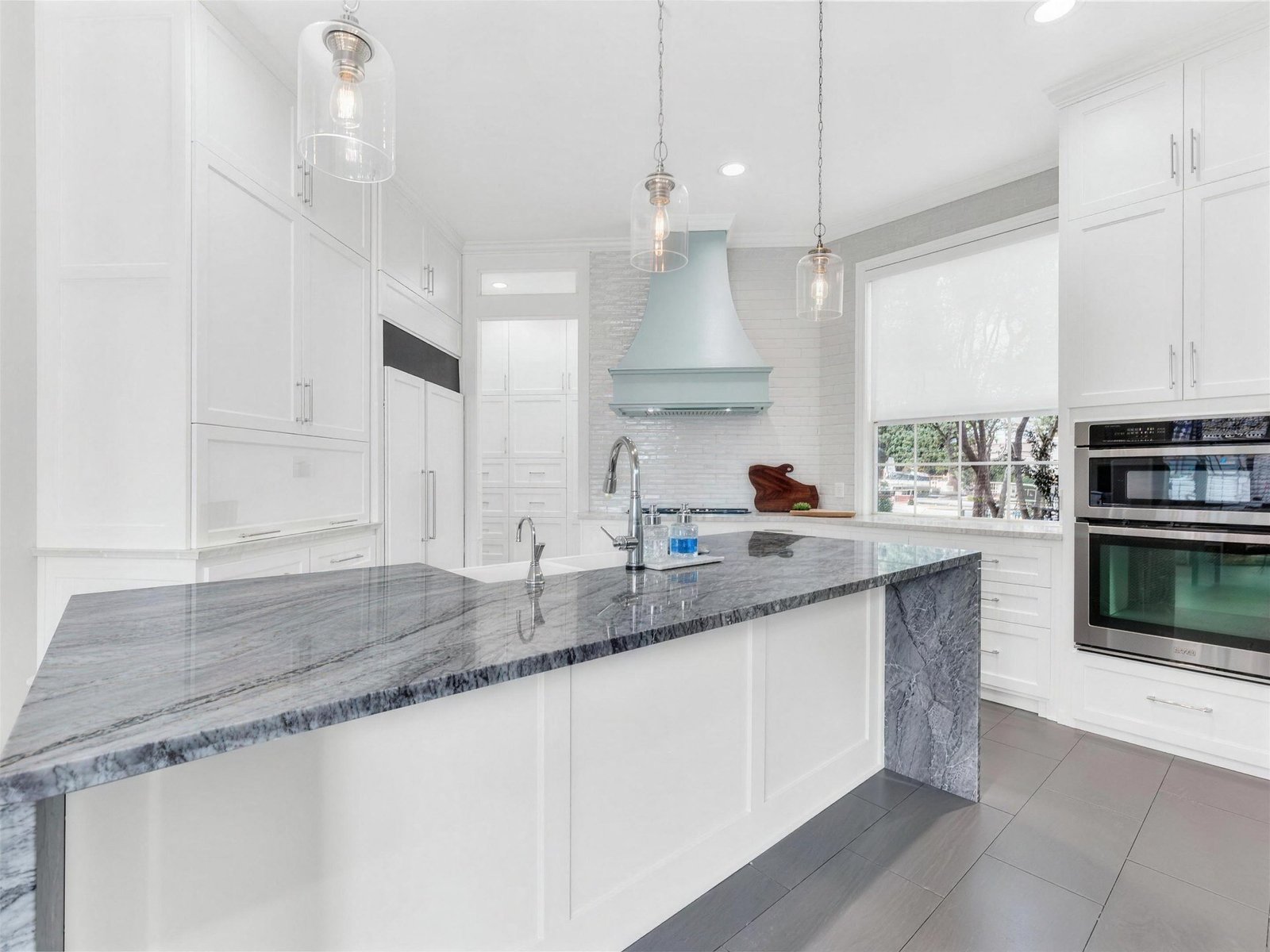 Kitchen remodel in Murphy, TX — quartzite waterfall island blue hood — UHS Remodeling project