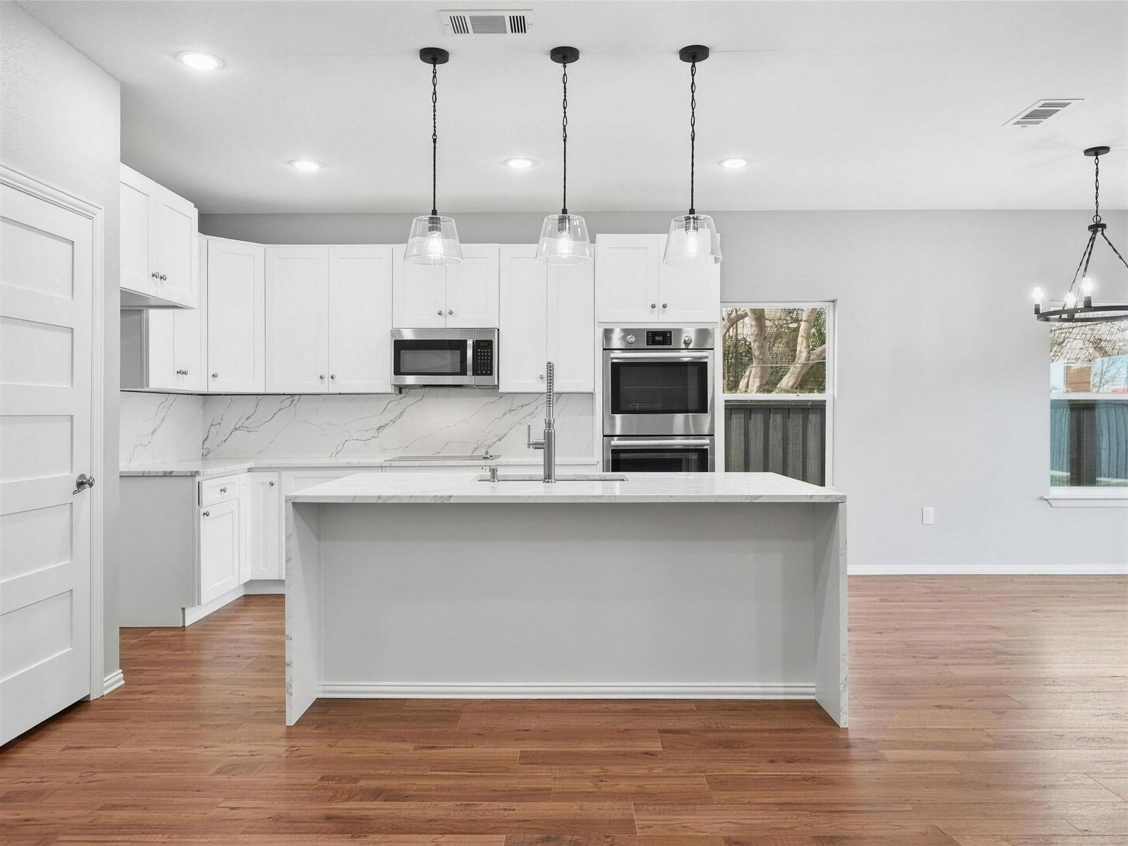 Kitchen remodel in Farmers Branch, TX — veined waterfall island pendants — UHS Remodeling project