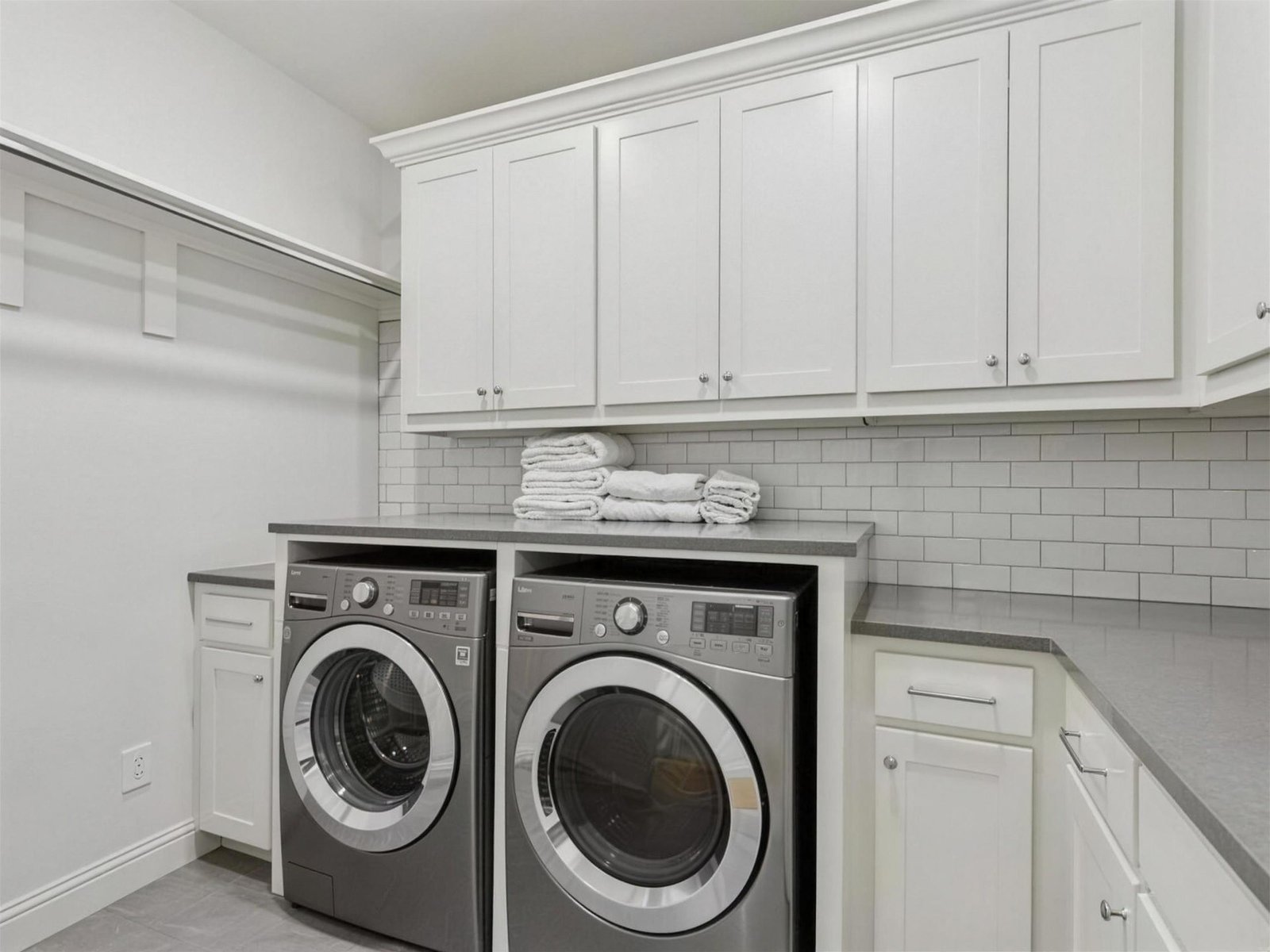 Laundry room remodel in University Park, TX — white cabinets subway backsplash — UHS Remodeling project