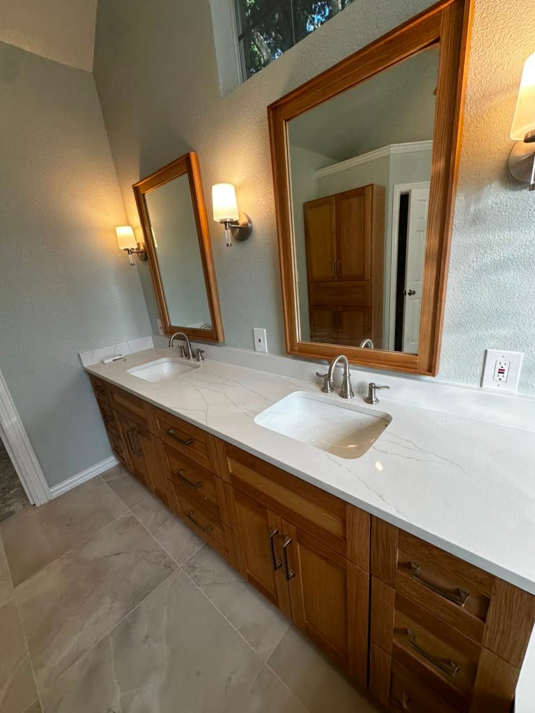 Custom shaker dual vanity with quartz countertop and wood-framed mirrors in a Plano master bathroom